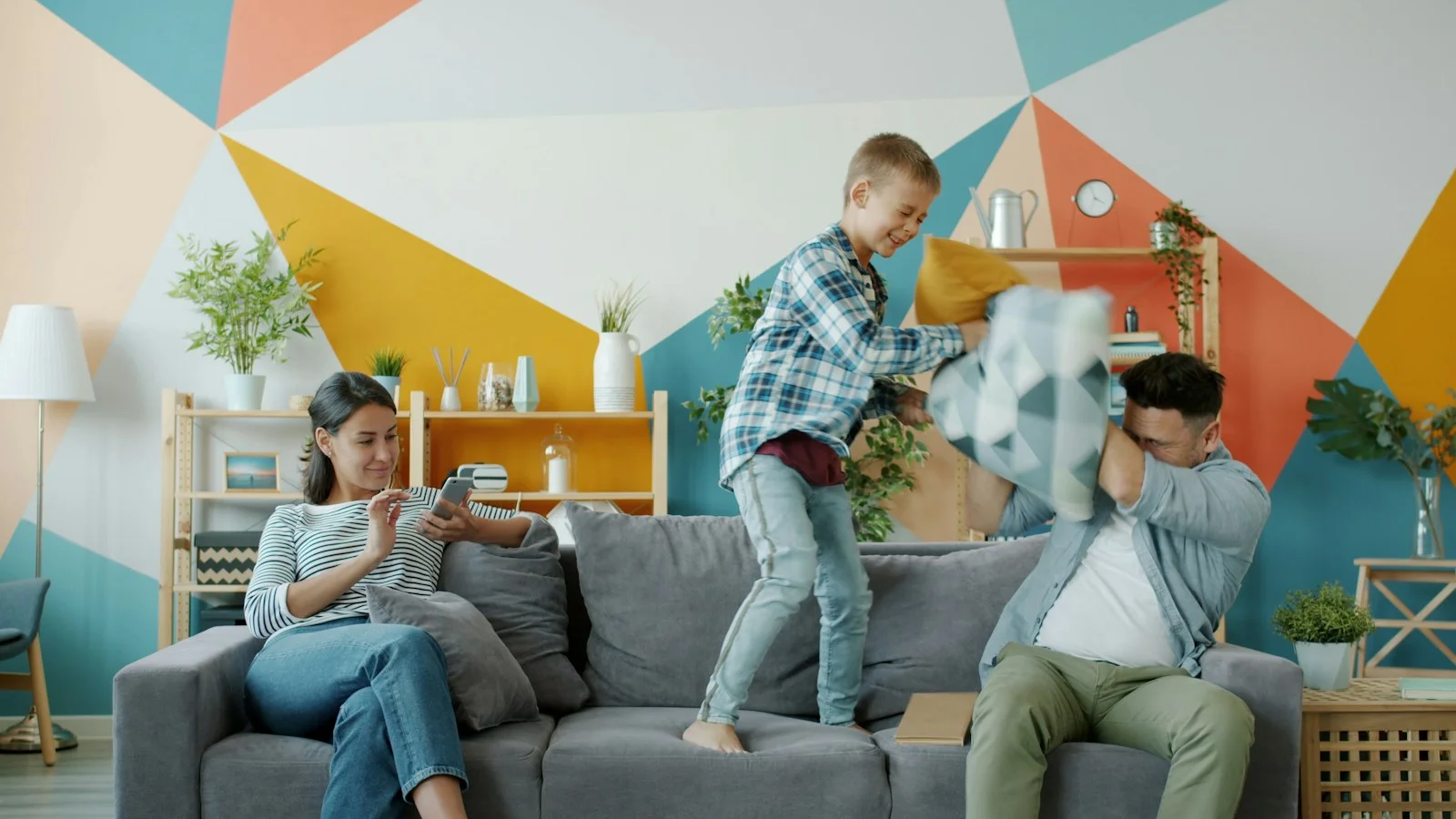 Family having a pillow fight on the couch Family having a pillow fight on the couch