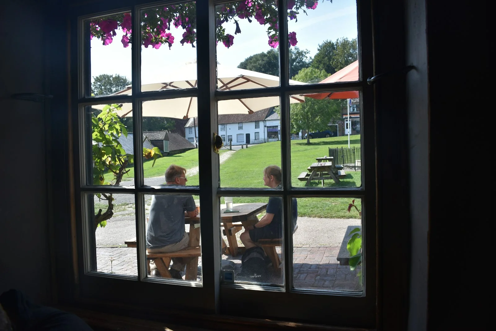 a couple of people sitting at a table in front of a window a couple of people sitting at a table in front of a window